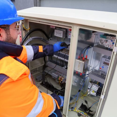 Eletricista avaliando disjuntor em quadro de força