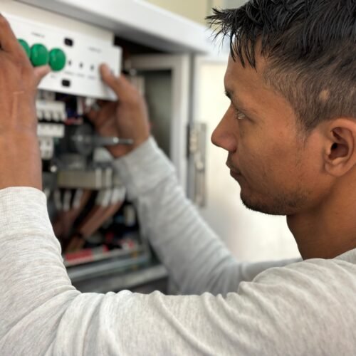 Eletricista trabalhando em painel elétrico