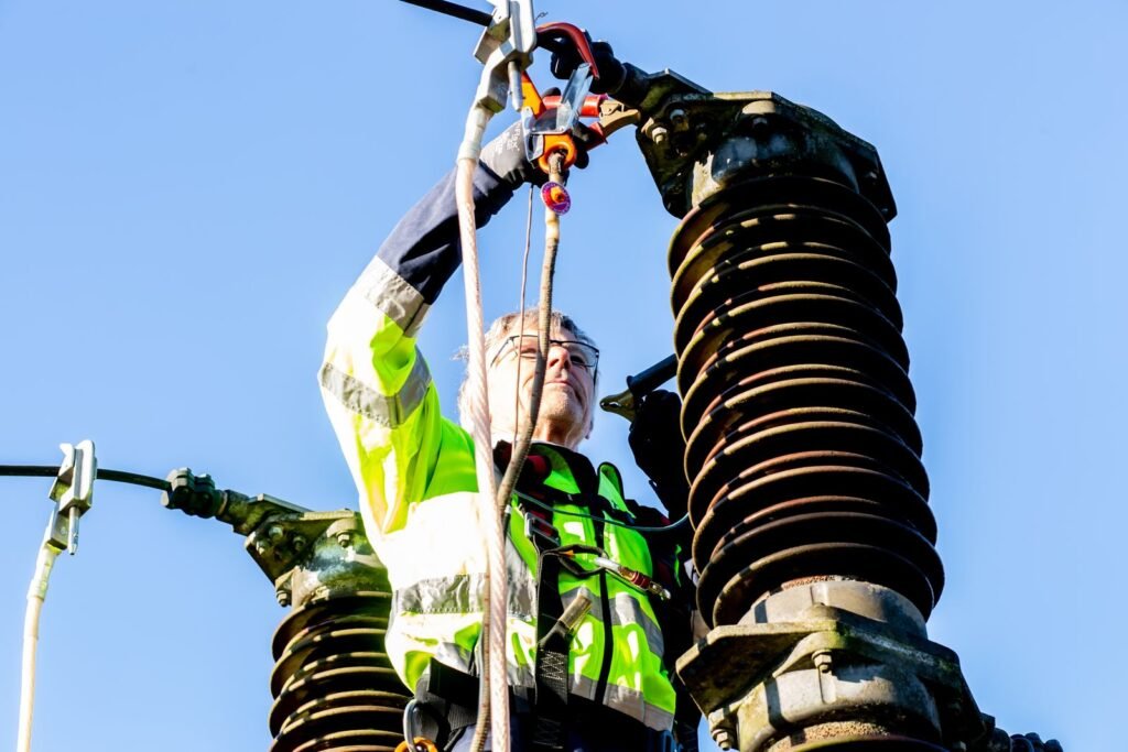 Eletricista trabalhando em torre de energia elétrica em atendimento na Consolação, São Paulo