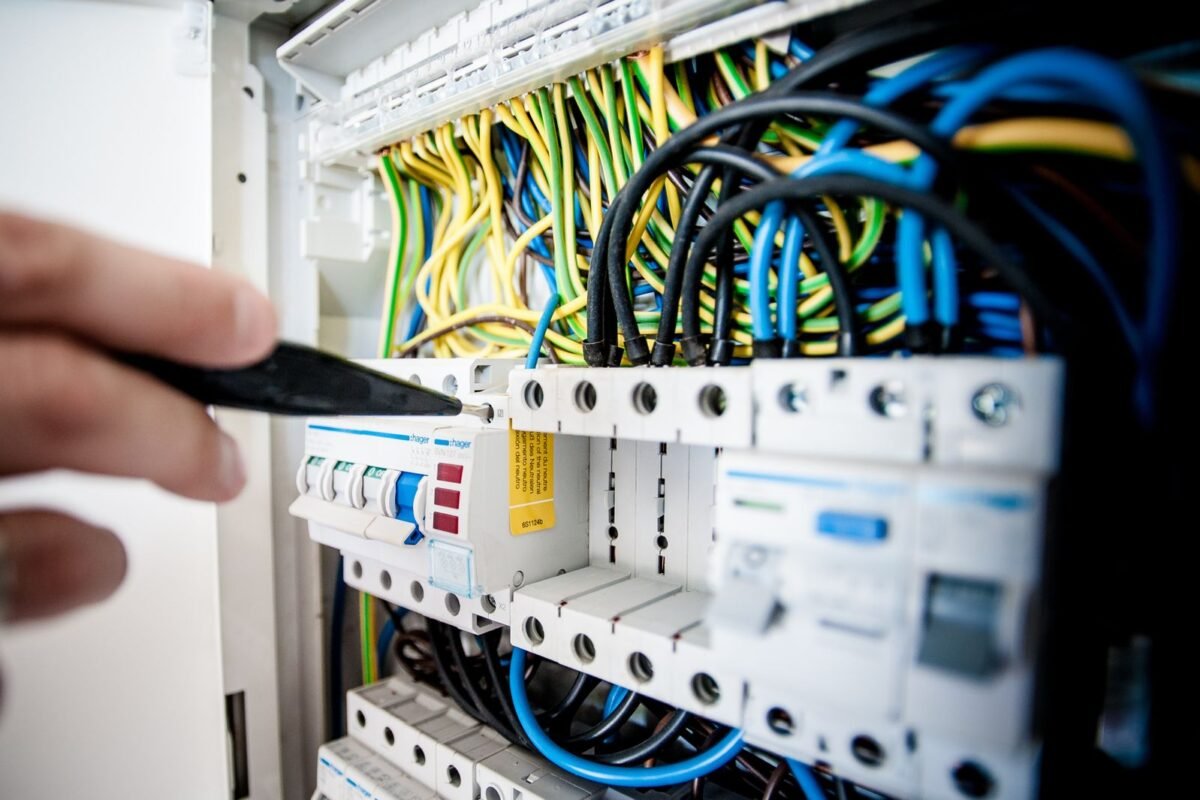 Eletricista realizando manutenção em quadro elétrico comercial de empresa em São Paulo