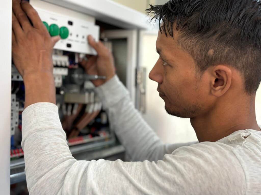 Eletricista trabalhando em painel elétrico em atendimento na Vila Mariana, São Paulo