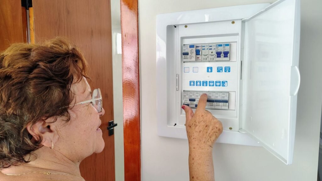 Eletricista revisando quadro elétrico em atendimento residencial na Vila Guilherme, São Paulo