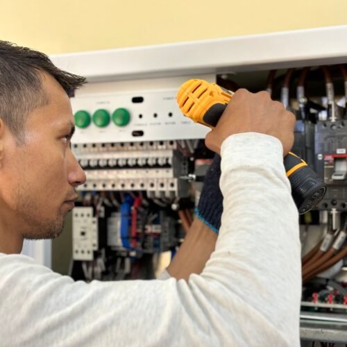 Eletricista realizando reparo em painel elétrico