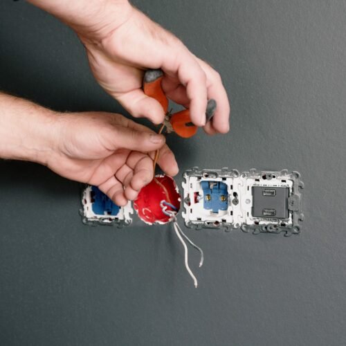Eletricista reparando tomada e interruptor em residência