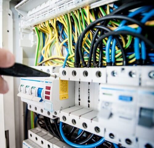 Eletricista realizando manutenção em quadro de disjuntores